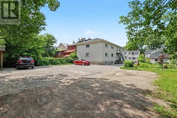 Perth apartment for rent - A gravel driveway leads to a white house with a red car parked in front.