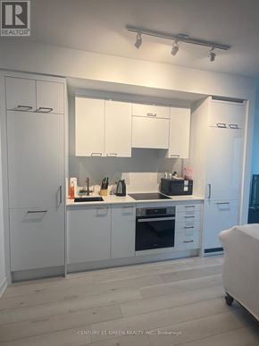 Toronto (Church-Yonge Corridor) condo for rent - A white kitchen with a refrigerator, oven, and cabinets.