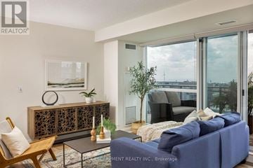 Toronto (Niagara) condo for rent - A living room with a blue couch and a glass table.
