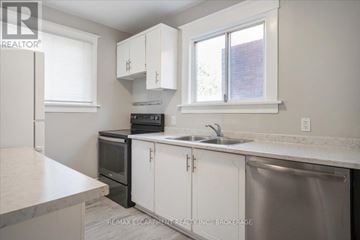 Thorold (Thorold Downtown) multi-family for rent - A kitchen with white cabinets and a stainless steel dishwasher.