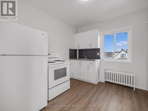 Thorold (Thorold Downtown) apartment for rent - A white refrigerator is in a kitchen with wood floors and white walls.