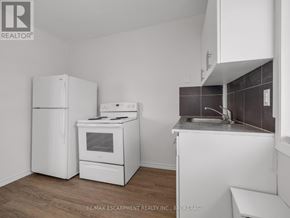 Thorold (Thorold Downtown) apartment for rent - A kitchen with white appliances and a wooden floor.