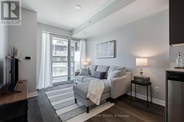 Burlington (Alton) condo for rent - A living room with a grey couch and a television.
