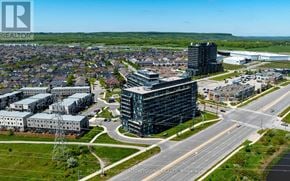 Burlington (Alton) condo for rent - A bird's eye view of a city with a large building in the foreground and a smaller building in the background.