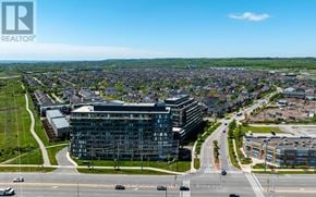 Burlington (Alton) condo for rent - A real estate company logo is displayed on an aerial view of a cityscape.