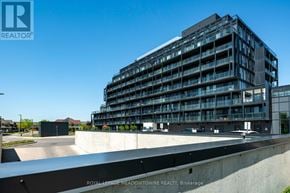 Burlington (Alton) condo for rent - A modern building with the sign "Royal LePage Meadowtowne Realty, Brokerage" in front of it.