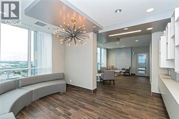 Burlington condo for rent - A living room with a grey couch and a wooden floor.