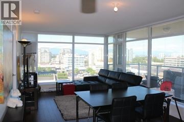 Richmond apartment for rent - A living room with a black couch and a table with chairs.