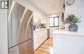 Vancouver apartment for rent - A modern kitchen with a stainless steel refrigerator and wooden floors.