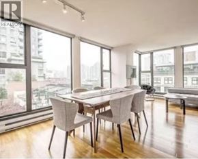 Vancouver apartment for rent - A dining room with a table and chairs with a view of the city.