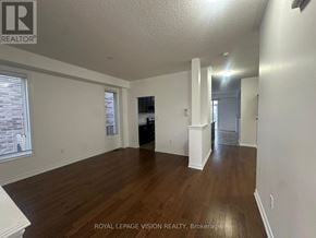 Oshawa (Samac) apartment for rent - A spacious room with wooden floors and white walls.