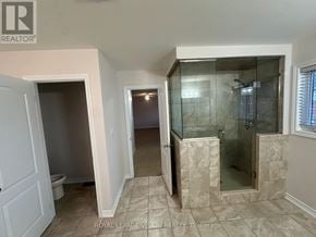 Oshawa (Samac) apartment for rent - A bathroom with a walk-in shower and a toilet.