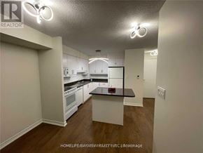 Mississauga (City Centre) condo for rent - A well-lit kitchen with white cabinets and a black countertop.