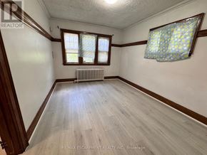 Burlington (Lasalle) apartment for rent - A room with wooden floors and a window with a blue curtain.