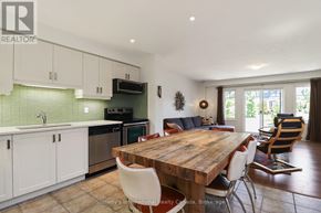Collingwood townhouse for rent - A kitchen with a wooden table and chairs, a microwave, and a sink.