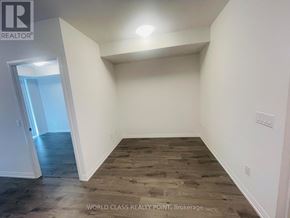 Toronto (Waterfront Communities) condo for rent - A room with wooden flooring and white walls, with a doorway leading to another room.