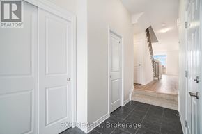 Russell townhouse for rent - A hallway with a staircase leading to the second floor.
