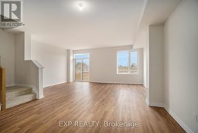 Russell townhouse for rent - A spacious room with wooden flooring and a staircase leading to another level.