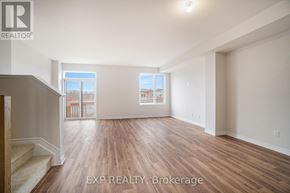 Russell townhouse for rent - A room with wooden flooring and a staircase on the left side.
