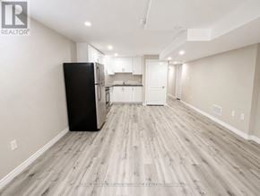 Milton (Be Beaty) apartment for rent - A spacious kitchen with a black refrigerator and wooden flooring.