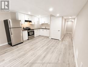 Milton (Be Beaty) apartment for rent - A kitchen with a refrigerator, oven, microwave, and cabinets.