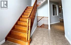 Ancaster apartment for rent - A wooden staircase with a railing leads to a second floor.