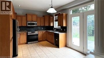 Ancaster apartment for rent - A kitchen with wooden cabinets and black countertops.