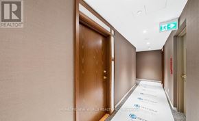 Vaughan (Concord) condo for rent - A hallway with a green exit sign above it.