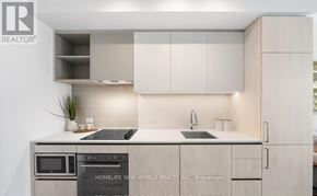 Vaughan (Concord) condo for rent - A modern kitchen with a stove top oven and microwave.