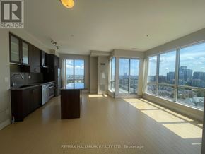 Richmond Hill (South Richvale) condo for rent - A spacious living room with a kitchen area and large windows overlooking the city.