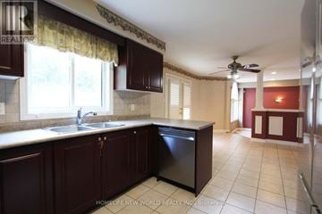 Barrie (Ardagh) apartment for rent - A kitchen with dark wood cabinets and a black dishwasher.