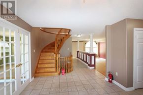 Barrie (Ardagh) apartment for rent - A spacious foyer with a wooden staircase and a red fire extinguisher.