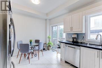 Toronto (Dovercourt-Wallace Emerson-Junction) townhouse for rent - A kitchen with a table and chairs in front of a window.