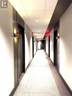 Toronto (High Park North) condo for rent - A long hallway with doors on both sides and a red light at the end.