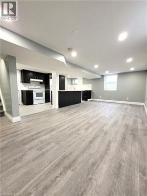 Cambridge apartment for rent - A spacious room with wood flooring and a kitchen area in the background.