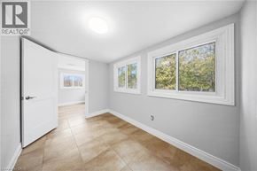 Cambridge apartment for rent - A room with a white door, a window with a view of trees, and a tiled floor.
