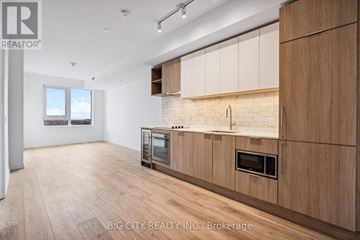 Toronto (Forest Hill South) condo for rent - A modern kitchen with wooden cabinets and a microwave built into the countertop.