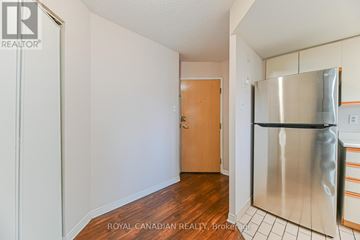 Toronto (Milliken) condo for rent - A kitchen with a refrigerator, wooden floors and white walls.