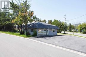 Sault Ste. Marie apartment for rent - A small building with a grey roof is situated on the side of a road.