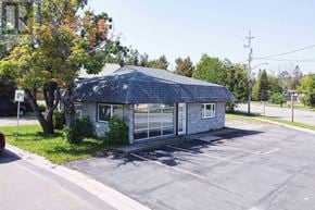 Sault Ste. Marie apartment for rent - A small building with a grey roof and a parking lot in front.