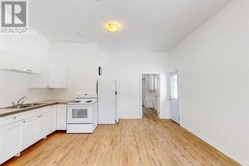 Sault Ste. Marie apartment for rent - A white kitchen with wooden floors and a refrigerator.