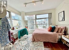 Toronto (Church-Yonge Corridor) condo for rent - A bedroom with a bed, a chair, a desk, and a window overlooking a cityscape.
