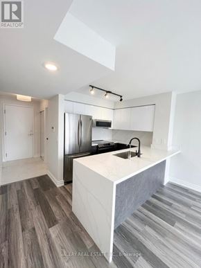 Toronto (Bendale) condo for rent - A modern kitchen with a white island and stainless steel appliances.
