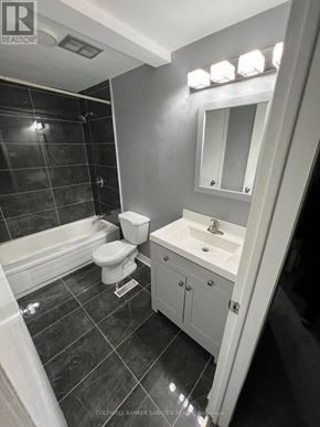 Ottawa townhouse for rent - A bathroom with a white sink, toilet, and bathtub.