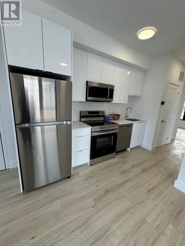Niagara Falls (Oldfield) townhouse for rent - A modern kitchen with white cabinets and stainless steel appliances.