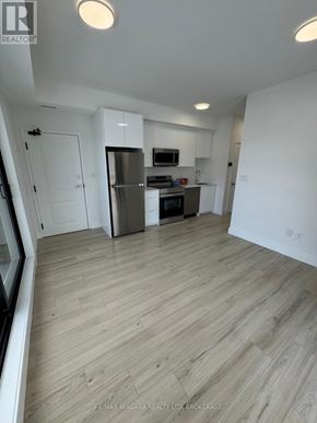 Niagara Falls (Oldfield) townhouse for rent - A spacious kitchen with a refrigerator, microwave, and oven.