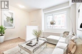 Toronto (Downsview-Roding-Cfb) townhouse for rent - A living room with a glass coffee table and a couch.