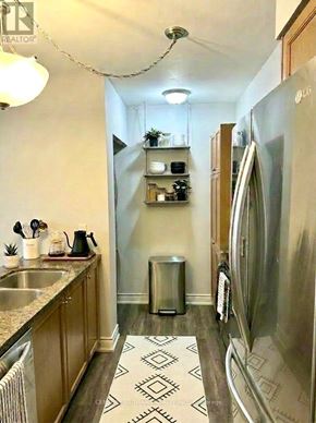 Toronto (Bayview Village) condo for rent - A kitchen with a sink, refrigerator, and a trash can.