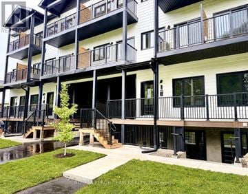 Ottawa townhouse for rent - A multi-story apartment building with balconies and a small tree in the courtyard.