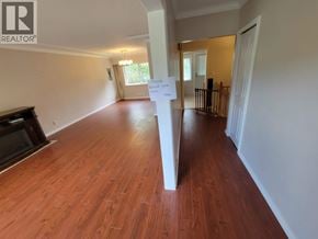 Burnaby apartment for rent - A room with wooden flooring and a white pillar in the middle.